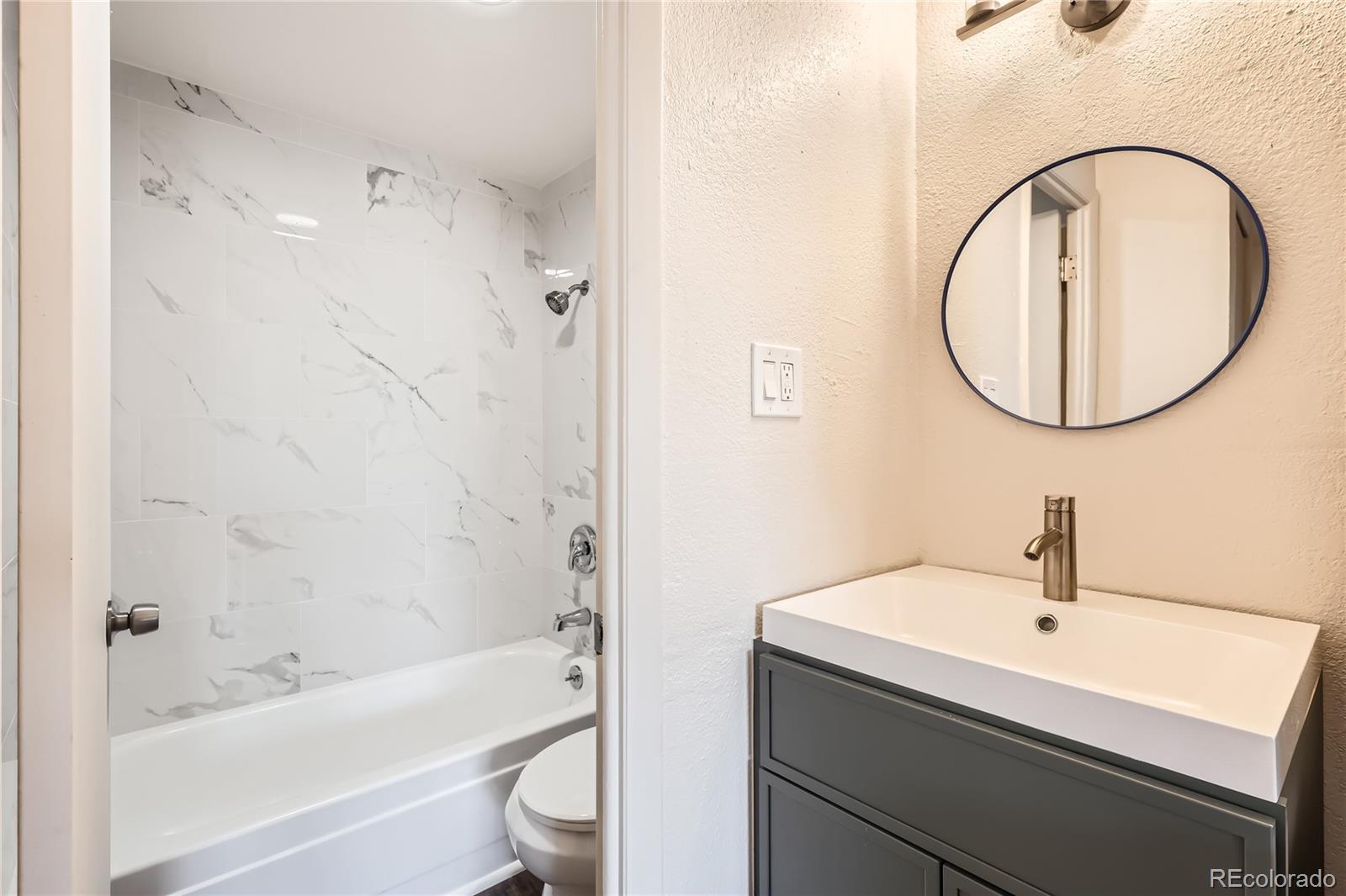 1302 South Parker Road, Unit 229 Denver, CO 80231 - Photo 6 of 18 a bathroom with a sink a toilet and a bathtub