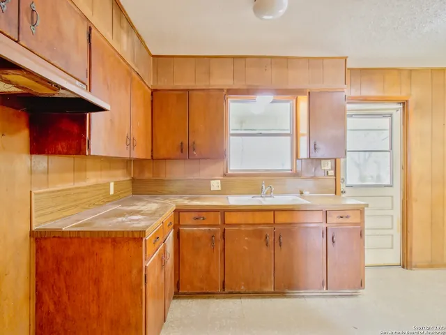 a kitchen with a sink a window stainless steel appliances and cabinets