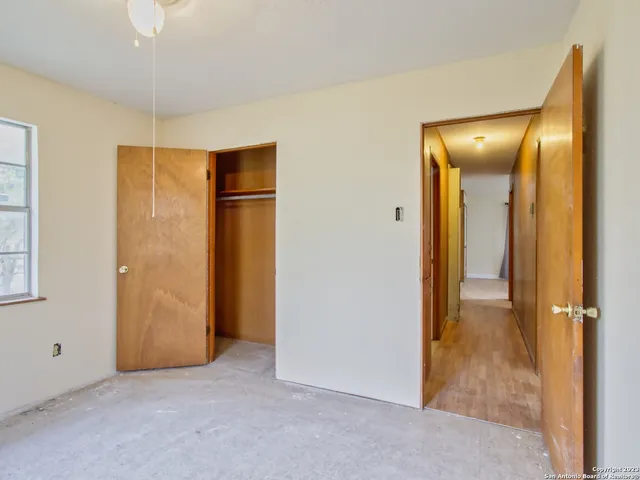 a view of an empty room with closet and a chandelier fan
