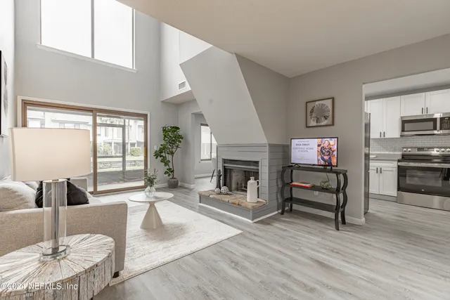 a living room with furniture a fireplace and a flat screen tv