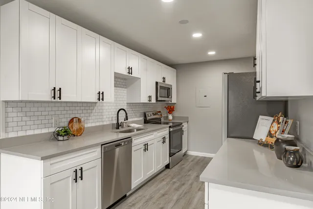 a kitchen with a sink a stove and cabinets