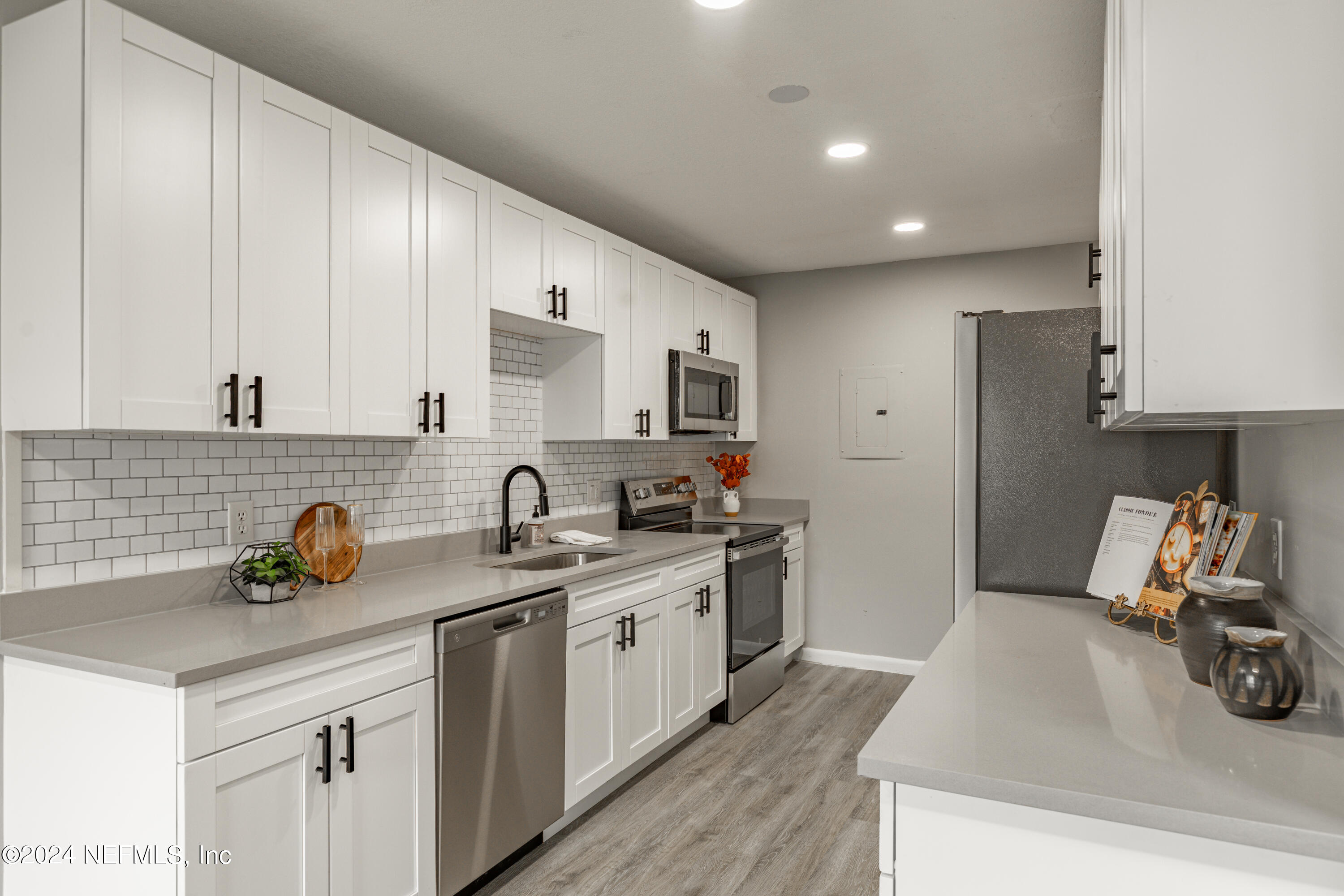 9360 Craven Road, Unit 504 Jacksonville, FL 32257 - Photo 9 of 28 a kitchen with a sink a stove and cabinets