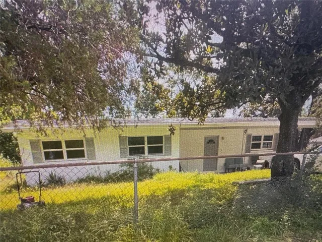 a view of a house with swimming pool next to a large tree