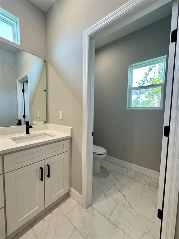 13081 Southwest 78th Circle Ocala, FL 34473 - Photo 13 of 22 a bathroom with a toilet sink and mirror