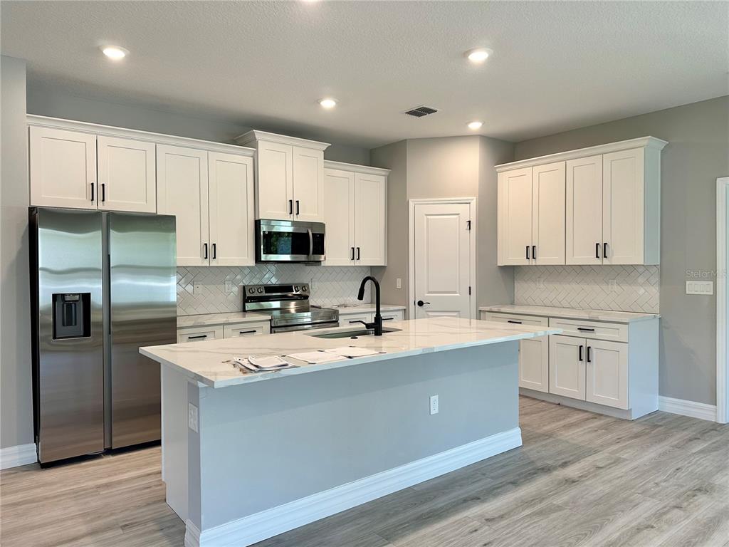 13081 Southwest 78th Circle Ocala, FL 34473 - Photo 3 of 22 a kitchen with stainless steel appliances granite countertop a sink refrigerator and microwave