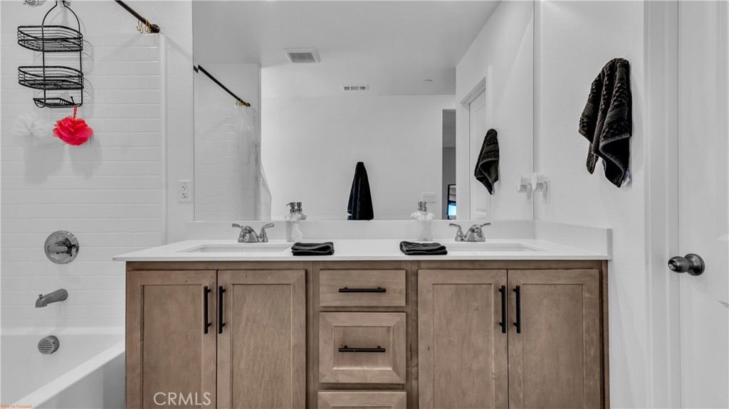 2271 Linden Lane Banning, CA 92220 - Photo 18 of 38 a bathroom with a double vanity sink a mirror and shower
