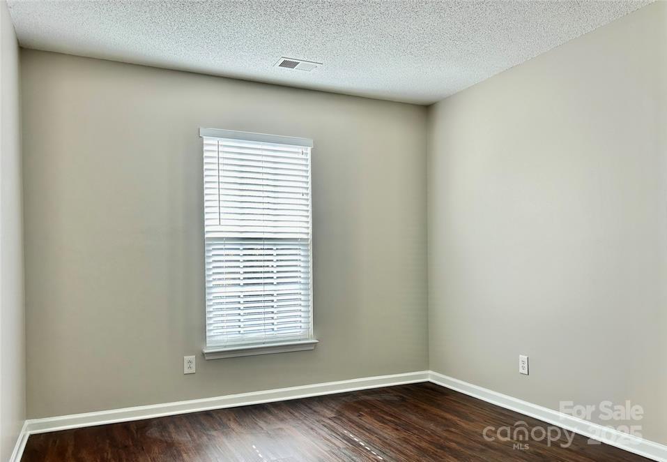 1021 Meadowbrook Lane Southwest Concord, NC 28027 - Photo 15 of 19 an empty room with wooden floor and a window