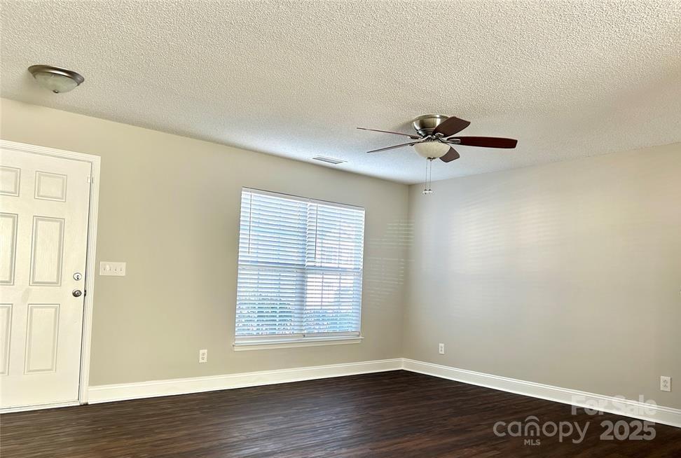 1021 Meadowbrook Lane Southwest Concord, NC 28027 - Photo 4 of 19 a view of an empty room with wooden floor and a window