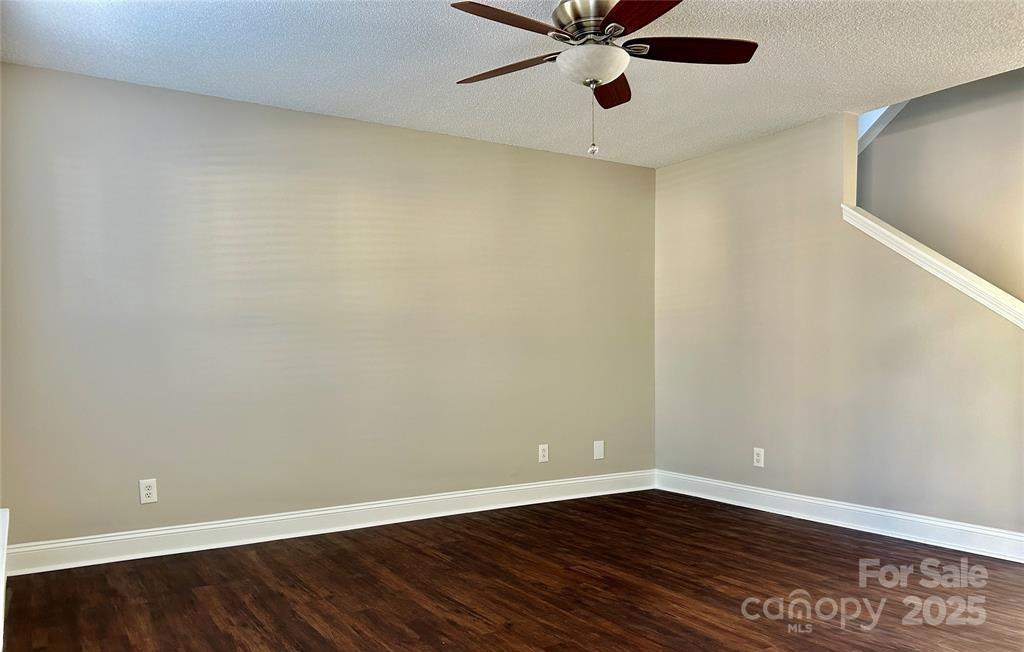 1021 Meadowbrook Lane Southwest Concord, NC 28027 - Photo 5 of 19 a view of an empty room with wooden floor and a ceiling fan