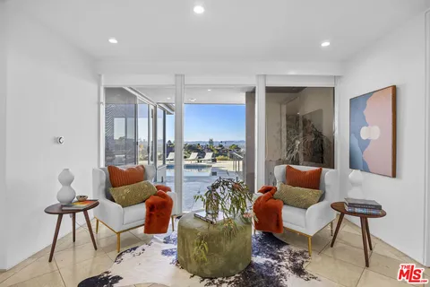 a view of a balcony with chairs and wooden floor
