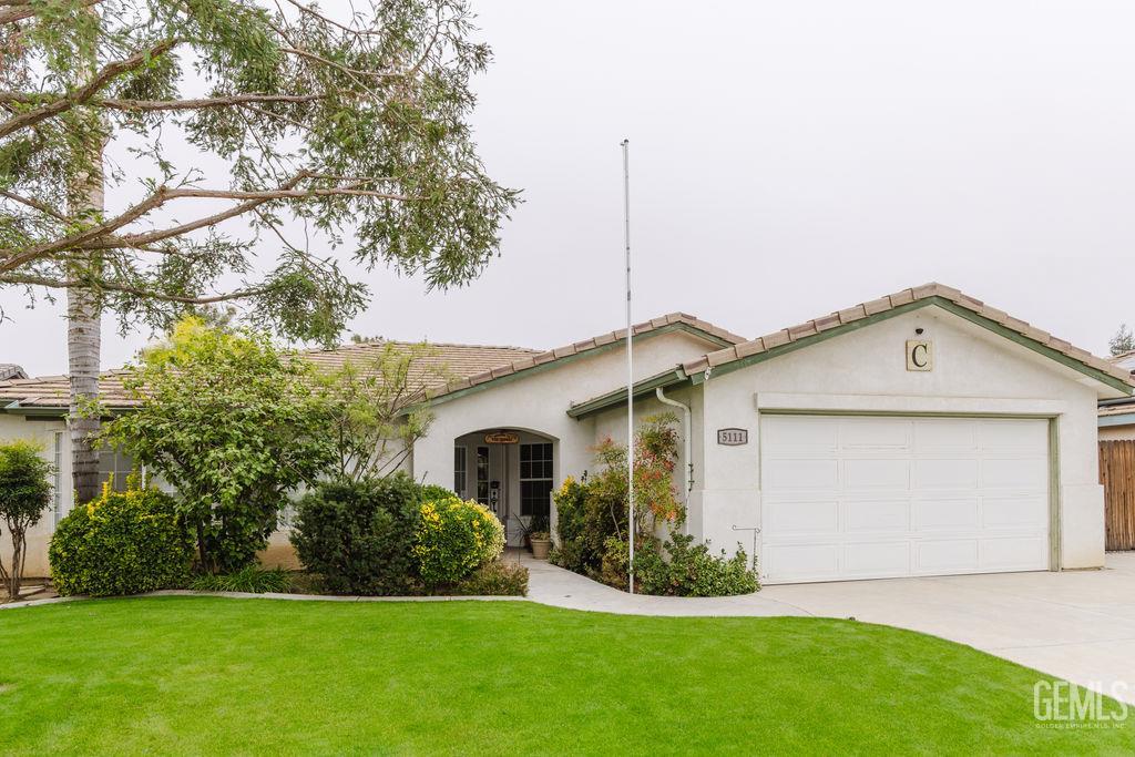 Undisclosed Address Bakersfield, CA 93308 - Photo 2 of 45 a front view of a house with a garden and yard
