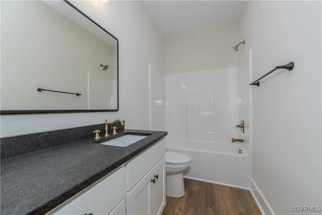 a bathroom with a granite countertop sink a toilet and shower
