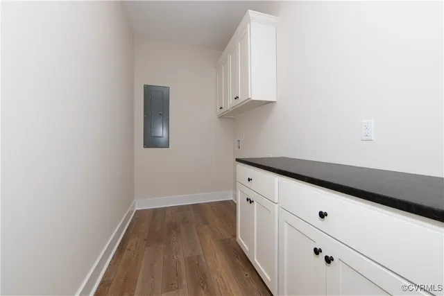 a kitchen with granite countertop white cabinets and wooden floor