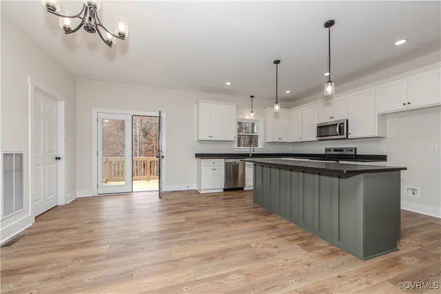 a kitchen with stainless steel appliances granite countertop a sink a stove and a wooden floors