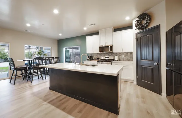 a kitchen with stainless steel appliances a sink stove refrigerator and cabinets