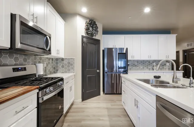 a kitchen with a sink a stove and cabinets
