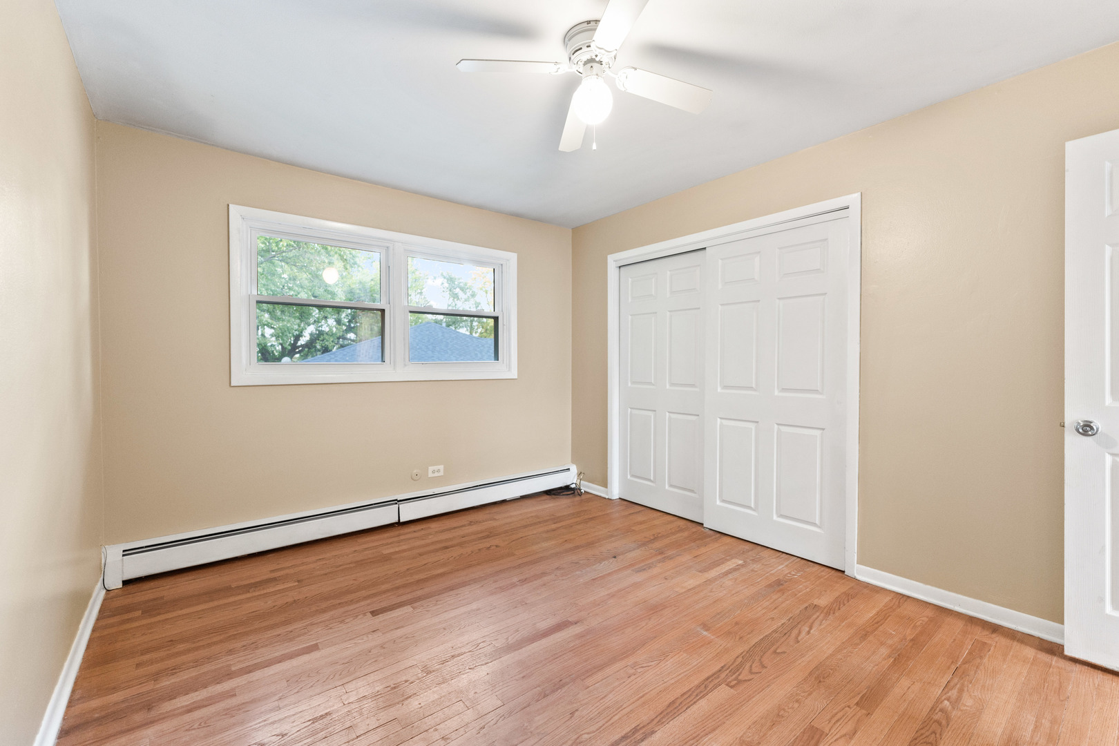 286 Wayne Court, Unit 2 Bartlett, IL 60103 - Photo 13 of 26 an empty room with wooden floor chandelier fan and windows