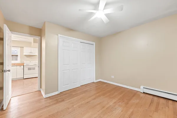 a large white kitchen with granite countertop a stove sink and cabinets