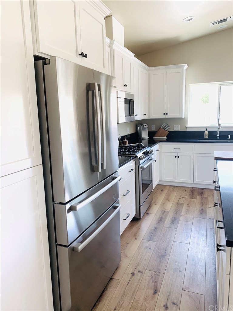 196 Rowan Way Templeton, CA 93465 - Photo 16 of 32 a kitchen with stainless steel appliances a refrigerator sink and wooden floor