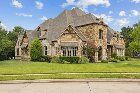 a front view of a house with a garden and yard