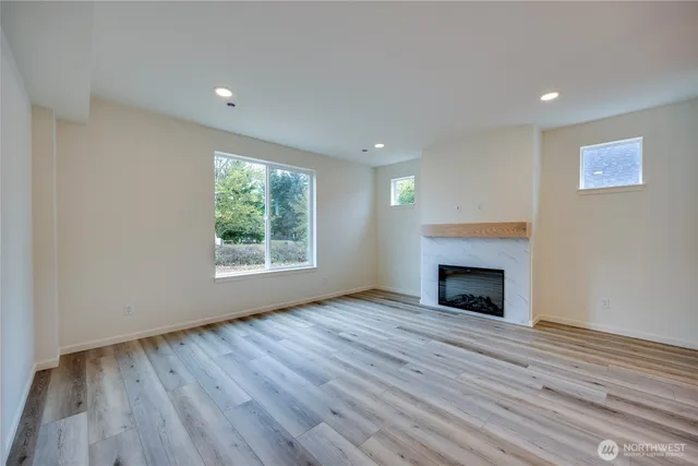 a view of empty room with wooden floor and fireplace