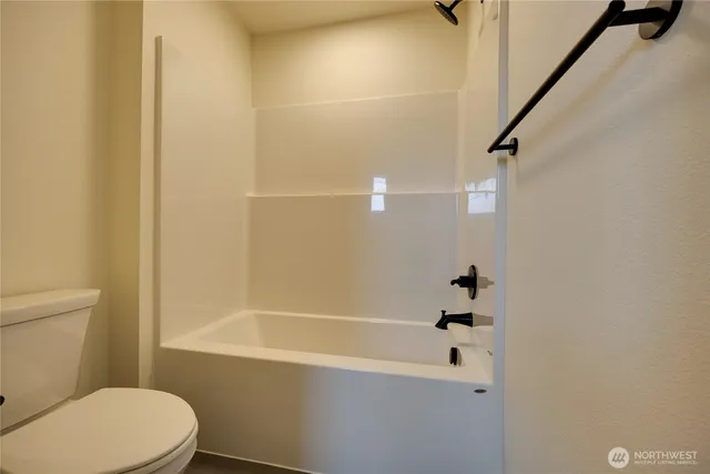 a white toilet sitting next to a bath tub