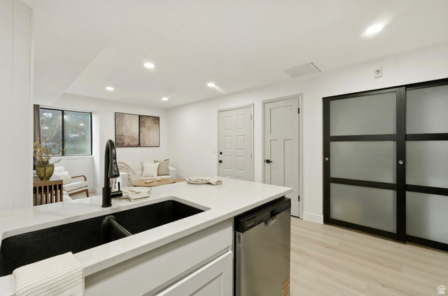 1175 Canyon Road, Unit 77 Ogden, UT 84404 - Photo 5 of 16 Kitchen with stainless steel dishwasher, light stone countertops, white cabinets, light wood-style flooring, and recessed lighting