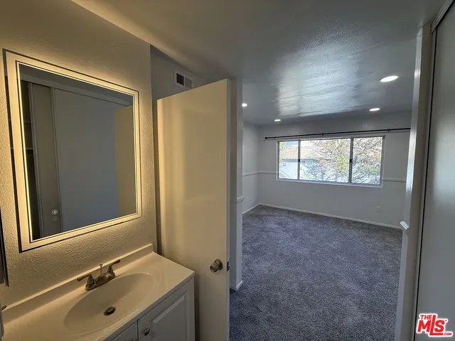 a bathroom with a sink mirror and window