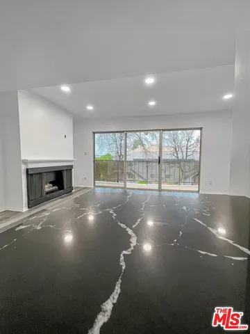 an empty room with a fireplace and windows