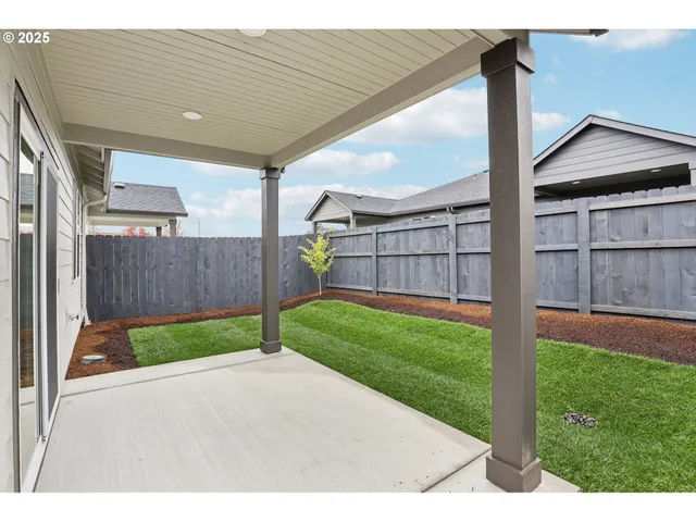 a view of a backyard with wooden fence