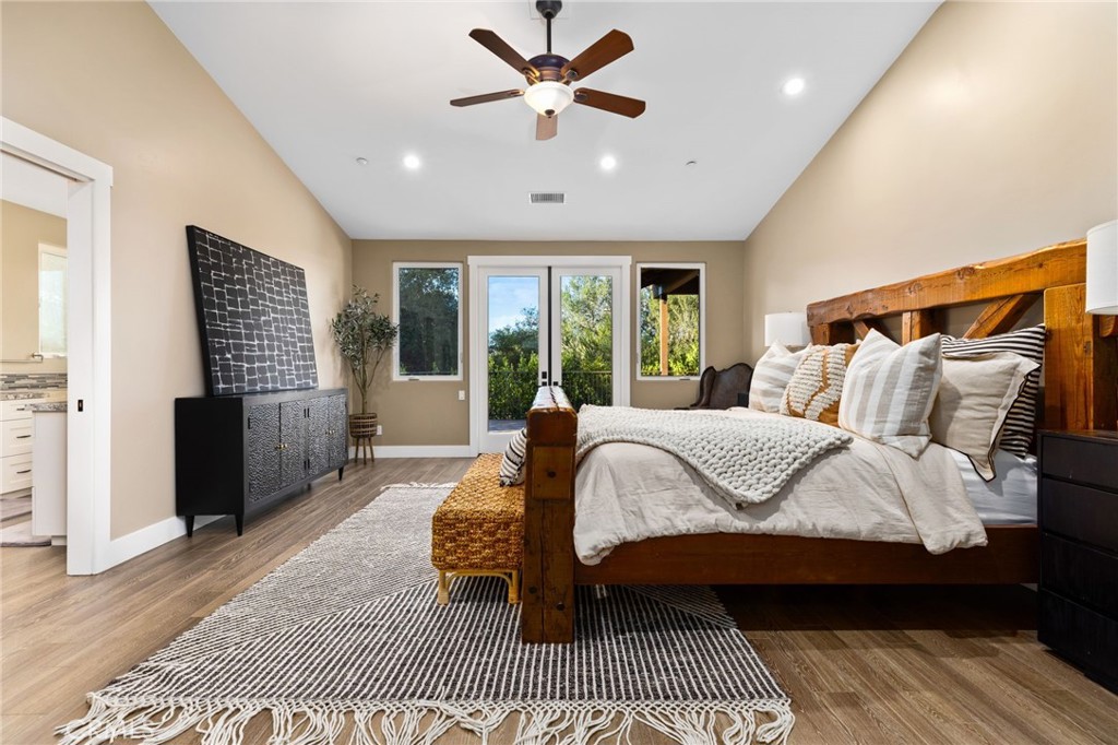 4007 Ladera Vista Road Fallbrook, CA 92028 - Photo 17 of 64 a spacious bedroom with a bed and a walk in closet with wooden floor