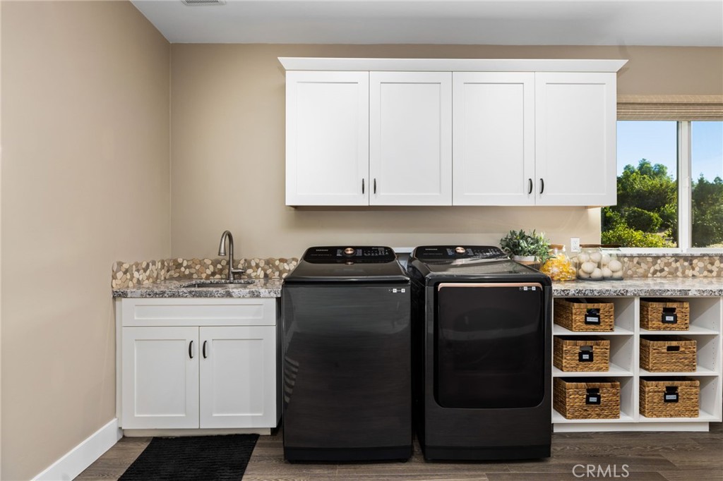 4007 Ladera Vista Road Fallbrook, CA 92028 - Photo 25 of 64 a view of a kitchen with granite countertop white cabinets and black appliances