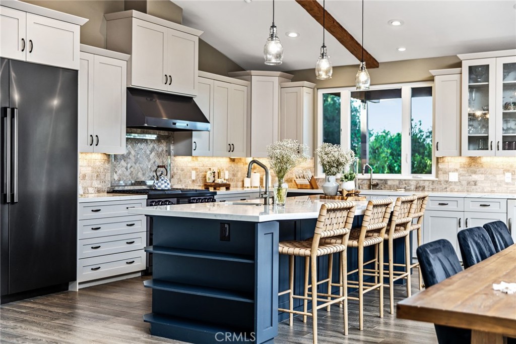 4007 Ladera Vista Road Fallbrook, CA 92028 - Photo 3 of 64 a kitchen with stainless steel appliances kitchen island granite countertop a table chairs and a refrigerator