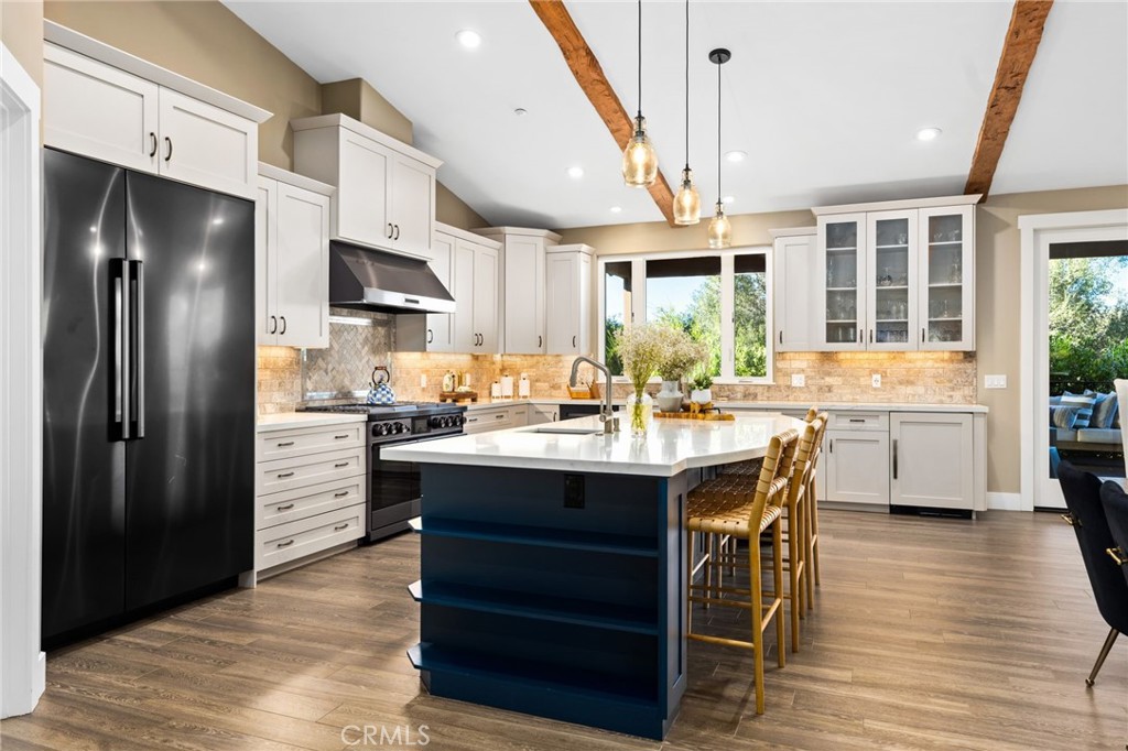 4007 Ladera Vista Road Fallbrook, CA 92028 - Photo 4 of 64 a kitchen with stainless steel appliances kitchen island granite countertop a refrigerator a sink dishwasher a stove and a dining table with wooden floor