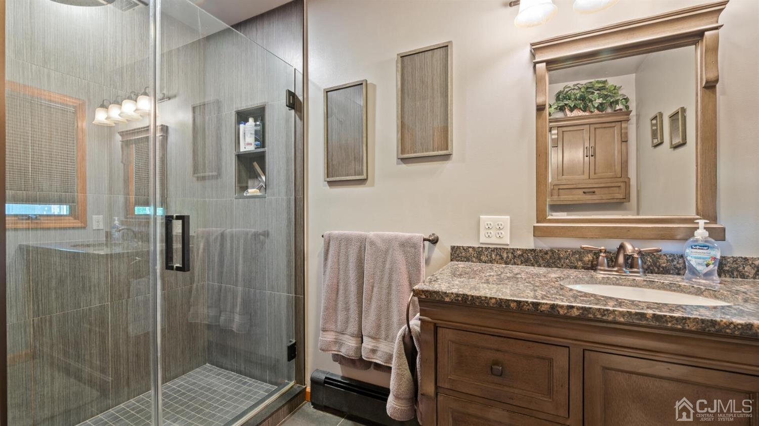 41 Dundee Road Kendall Park, NJ 08824 - Photo 26 of 42 a bathroom with a granite countertop sink a mirror a vanity and a shower