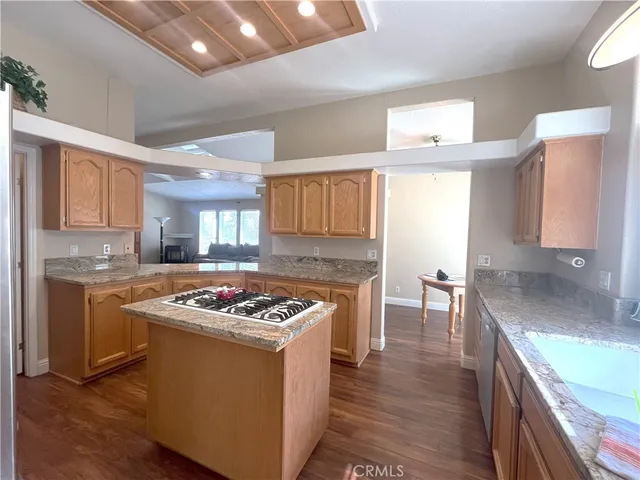 a kitchen with stainless steel appliances granite countertop a refrigerator a stove a sink and dishwasher with wooden floor