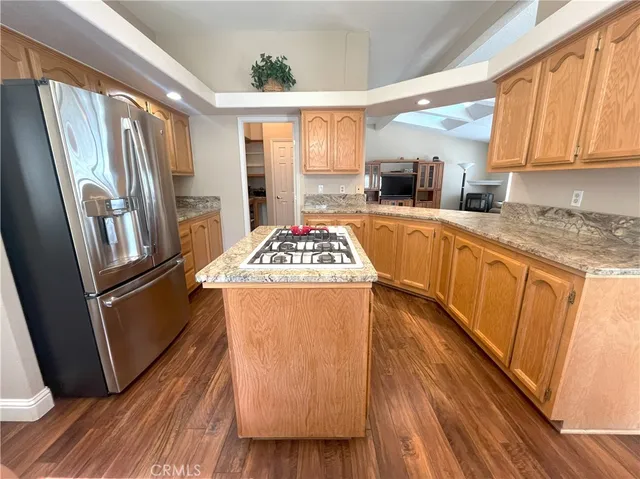 a kitchen with kitchen island granite countertop a stove and a sink