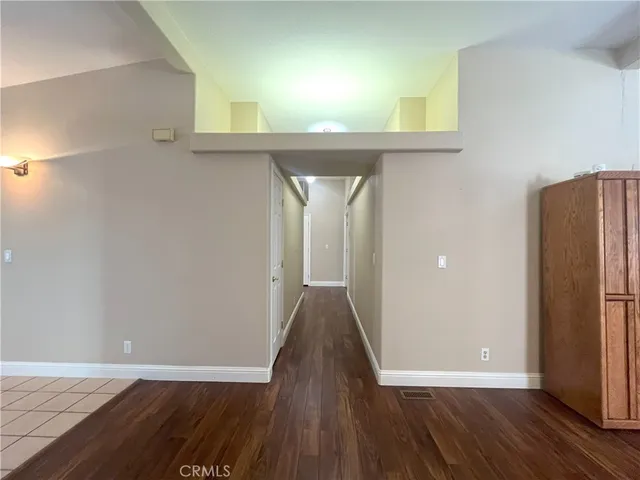 an empty room with wooden floor and closet area