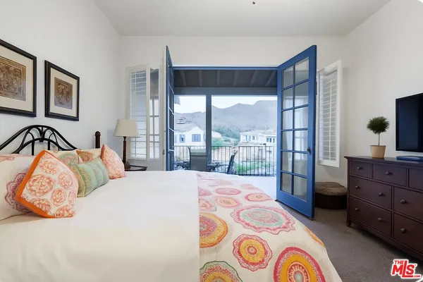 a bedroom with a bed and a large window