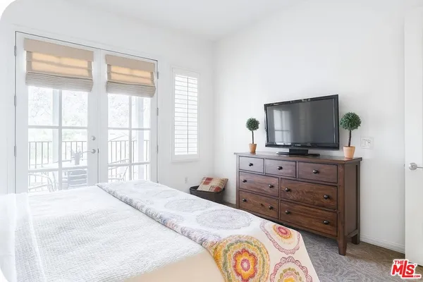 a bedroom with a bed and a flat screen tv