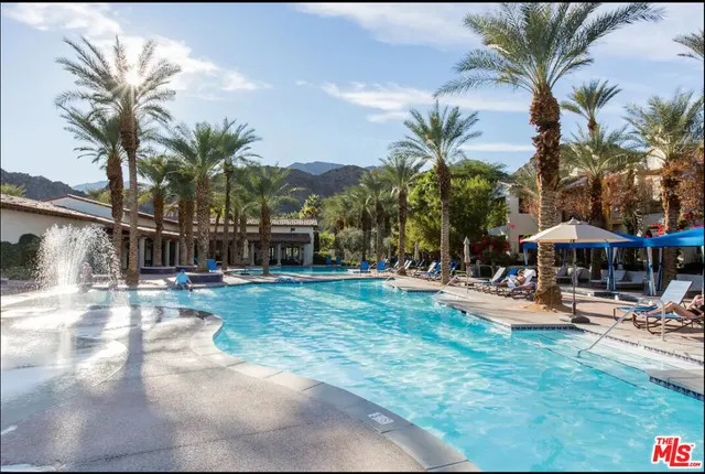 a view of a swimming pool with lounge chairs in patio