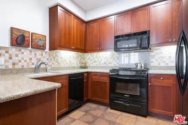 a kitchen with stainless steel appliances granite countertop a stove microwave and sink