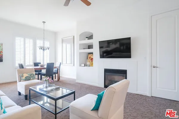 a living room with furniture a flat screen tv and a fireplace