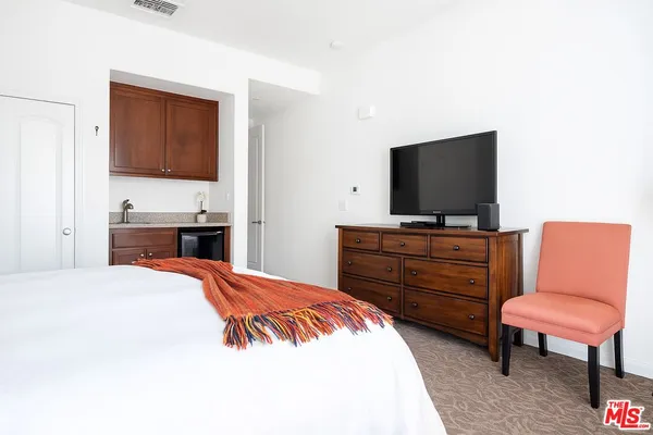 a bedroom with a bed and a flat screen tv