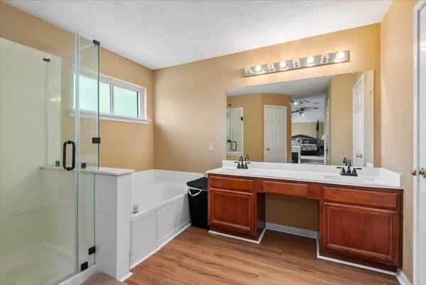 a spacious bathroom with a tub sink and mirror