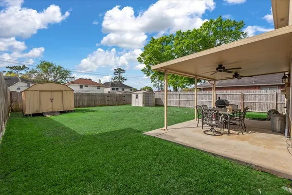 a view of a patio with a table chairs and a yard