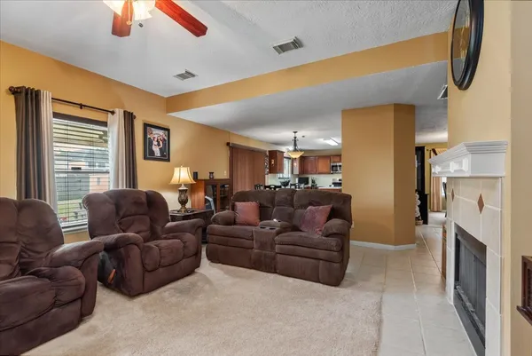 a living room with furniture a fireplace and a flat screen tv