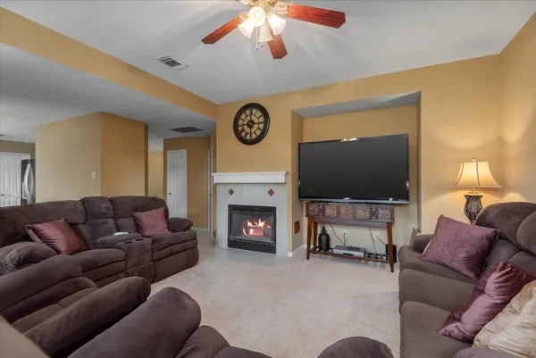 a living room with furniture a fireplace and a flat screen tv