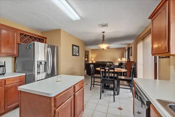 a kitchen with refrigerator cabinets dining table and chairs
