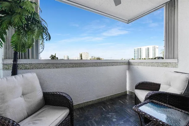 a view of a balcony with chairs and a potted plant